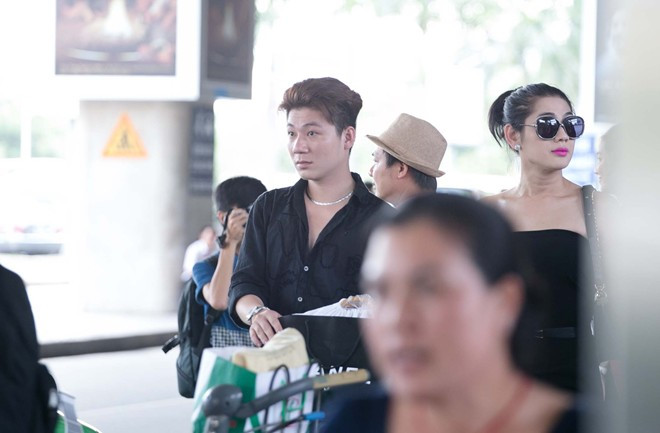 Hai người đứng xếp hàng chờ taxi..