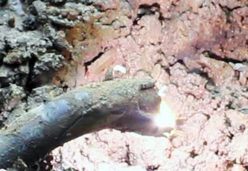 Khi kích điện, đầu cáp dưới hố nổ và bắn tia lửa điện. Ảnh: An Nhơn. Khi kích điện, đầu cáp dưới hố nổ và bắn tia lửa điện. Ảnh: An Nhơn