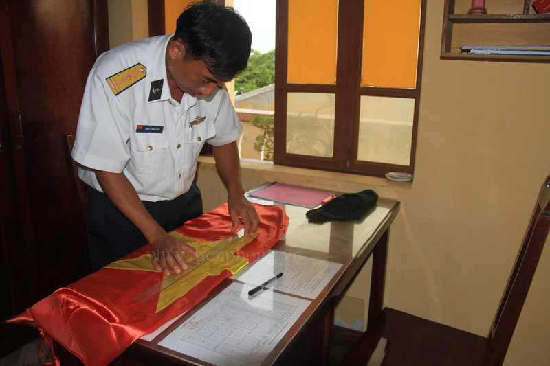 Những lá cờ đã qua sử dụng được các đảo lưu giữ lại và tặng cho các đoàn khách đến thăm. (Trong ảnh là cán bộ đảo Sinh Tồn đang chuẩn bị lá cờ tặng báo Tiền Phong). Ảnh: Trường Phong