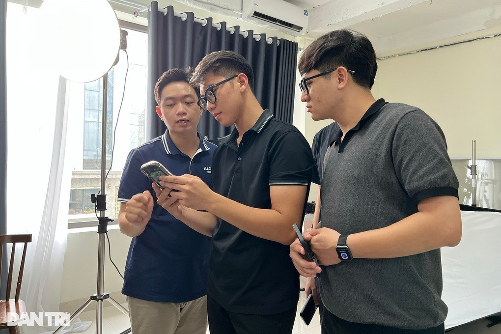 Minh Quang (giữa) đang đứng xem lại các bức ảnh mình vừa thực hành.