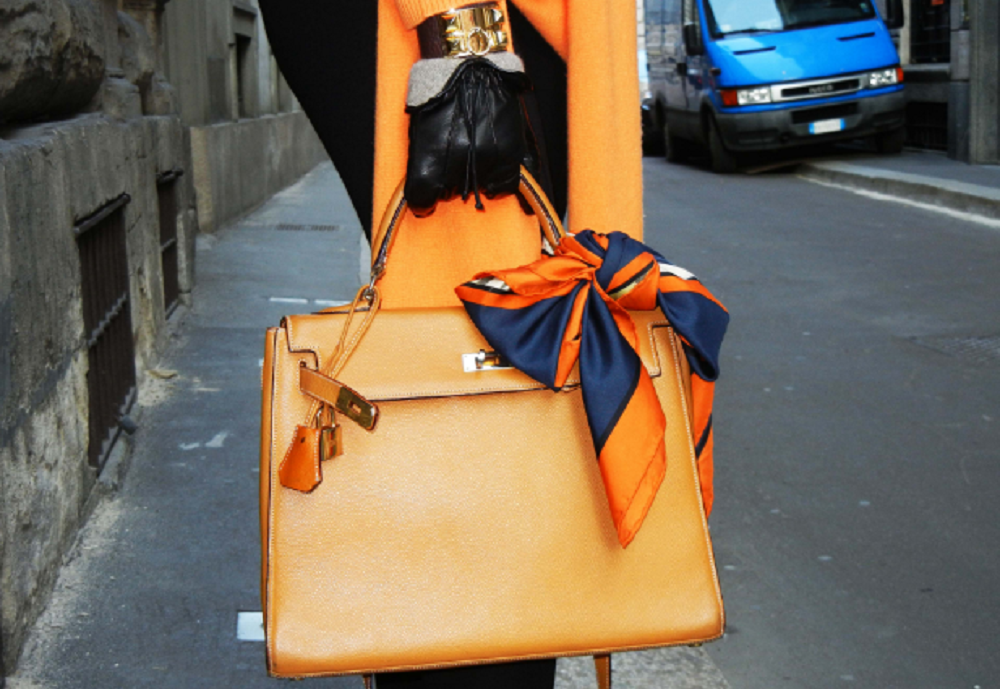 Các tín đồ thời trang từ xưa đến nay luôn yêu thích việc buộc khăn lụa thành một chiếc nơ, hoặc quấn khăn quanh quai túi xách.
