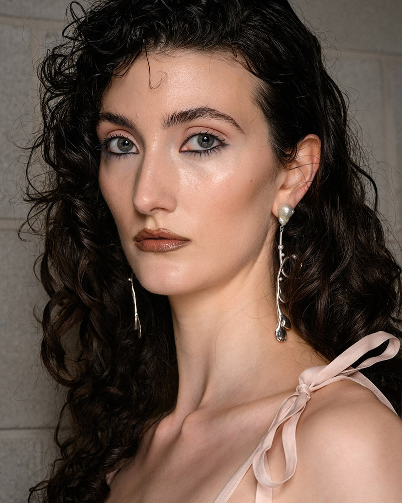 Kẻ viền môi màu nâu trầm trên nền da trong suốt, mang lại một sự lạnh lẽo và toát lên quyền lực của sắc đẹp.