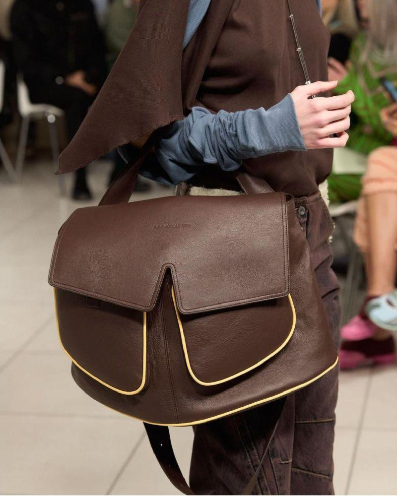 Chất liệu túi satchel thường được làm bằng da dày, gấp lại và thõng xuống cẳng tay.