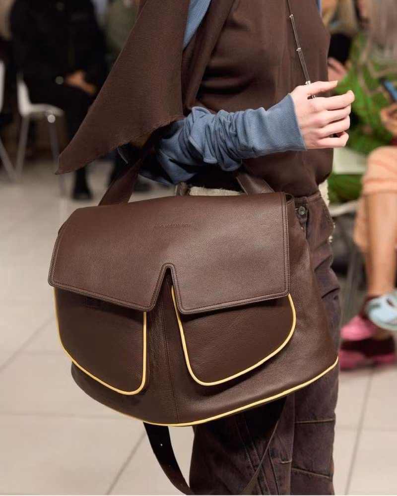Chất liệu túi satchel thường được làm bằng da dày, gấp lại và thõng xuống cẳng tay.