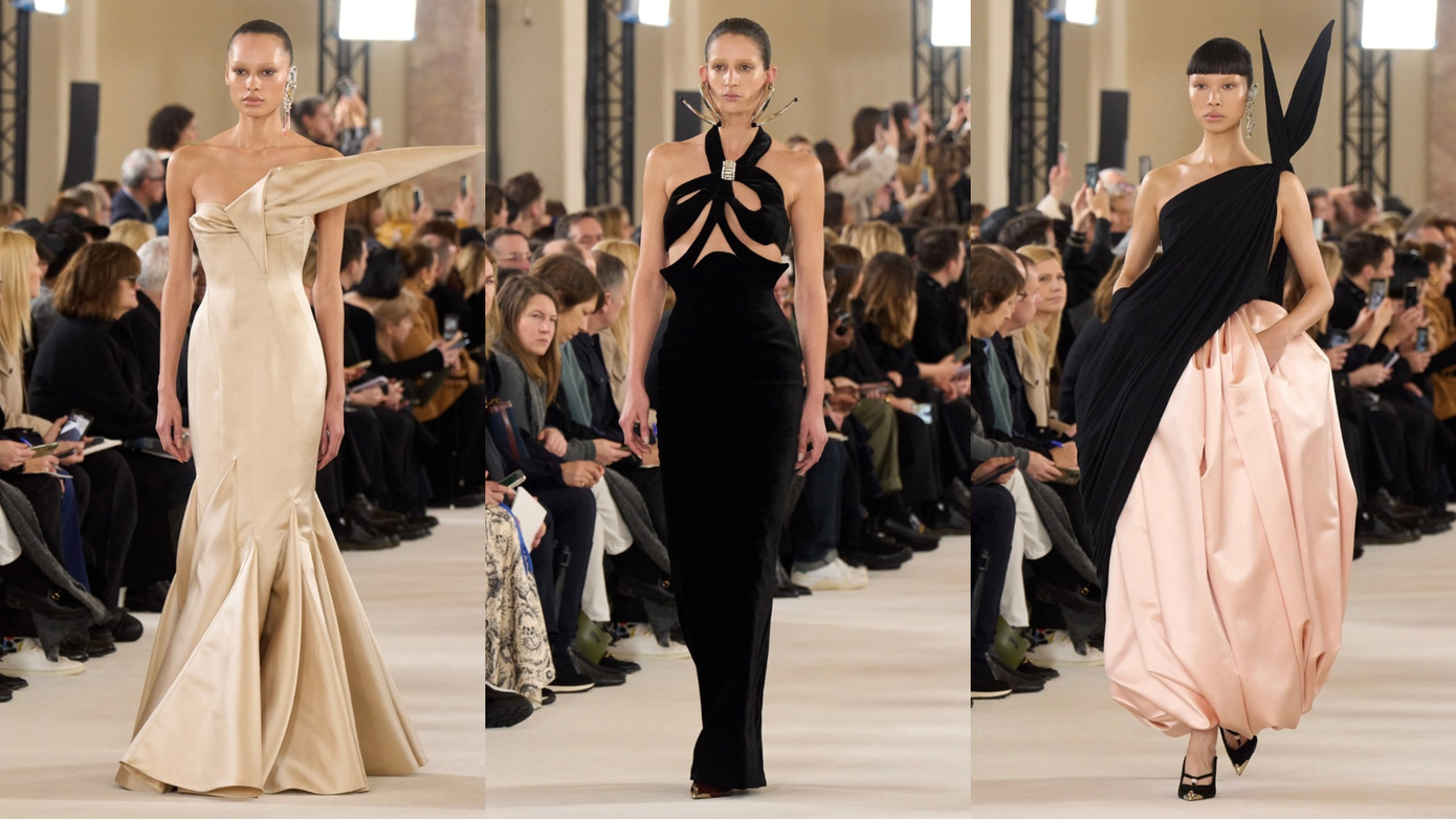 Một chiếc váy phồng làm bằng satin màu hồng, bên trên là một chiếc áo len đen bất đối xứng. Một chiếc váy phồng làm bằng satin màu hồng, bên trên là một chiếc áo len đen bất đối xứng.