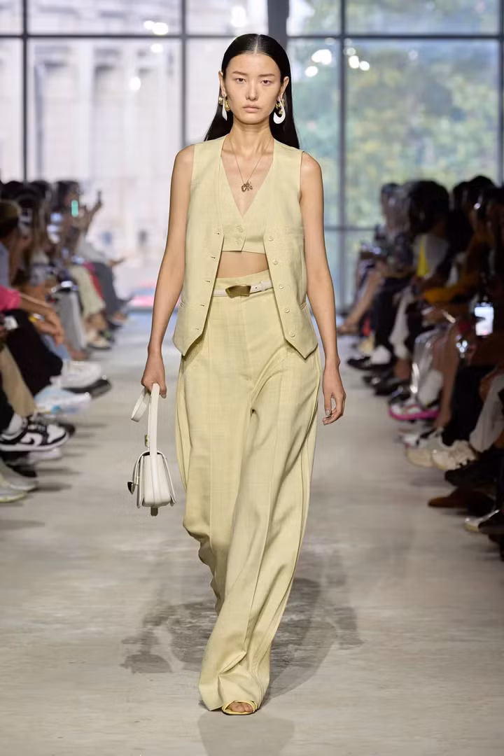 Người mẫu trên sàn diễn 3.1 Phillip Lim Xuân - Hè 2024 mặc áo ghi lê, áo bra top và quần dài đều màu vàng bơ. Người mẫu trên sàn diễn 3.1 Phillip Lim Xuân - Hè 2024 mặc áo ghi lê, áo bra top và quần dài đều màu vàng bơ.