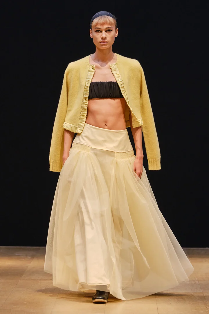 Người mẫu sàn diễn Molly Goddard Xuân - Hè 2024 với áo khoác màu vàng bơ và váy đồng điệu. Người mẫu sàn diễn Molly Goddard Xuân - Hè 2024 với áo khoác màu vàng bơ và váy đồng điệu.