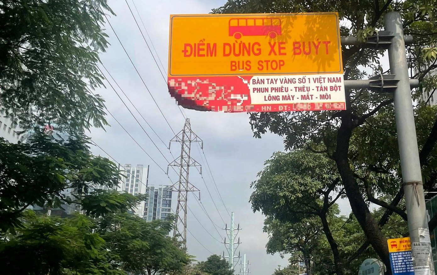 Một biển báo điểm chờ xe buýt khác thường so với các điểm chờ xe buýt khác được kèm với biển quảng cáo của một thẩm mỹ viện bị xe đâm móp mép trên phố Tam Trinh. Một biển báo điểm chờ xe buýt khác thường so với các điểm chờ xe buýt khác được kèm với biển quảng cáo của một thẩm mỹ viện bị xe đâm móp mép trên phố Tam Trinh.