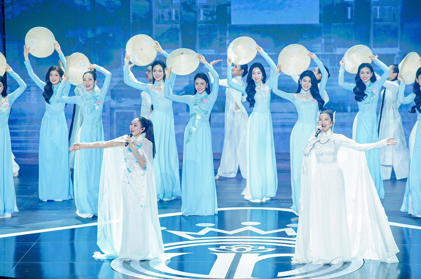 41 thí sinh đồng diễn áo dài trên nền nhạc Việt Nam hào quang rực sáng, được dàn dựng công phu kết hợp giữa âm nhạc, vũ đạo và tà áo dài truyền thống, chiếc nón lá. Phần thi thể hiện đậm nét tinh thần dân tộc và vẻ đẹp nữ tính của người phụ nữ Việt Nam. 41 thí sinh đồng diễn áo dài trên nền nhạc Việt Nam hào quang rực sáng, được dàn dựng công phu kết hợp giữa âm nhạc, vũ đạo và tà áo dài truyền thống, chiếc nón lá. Phần thi thể hiện đậm nét tinh thần dân tộc và vẻ đẹp nữ tính của người phụ nữ Việt Nam.
