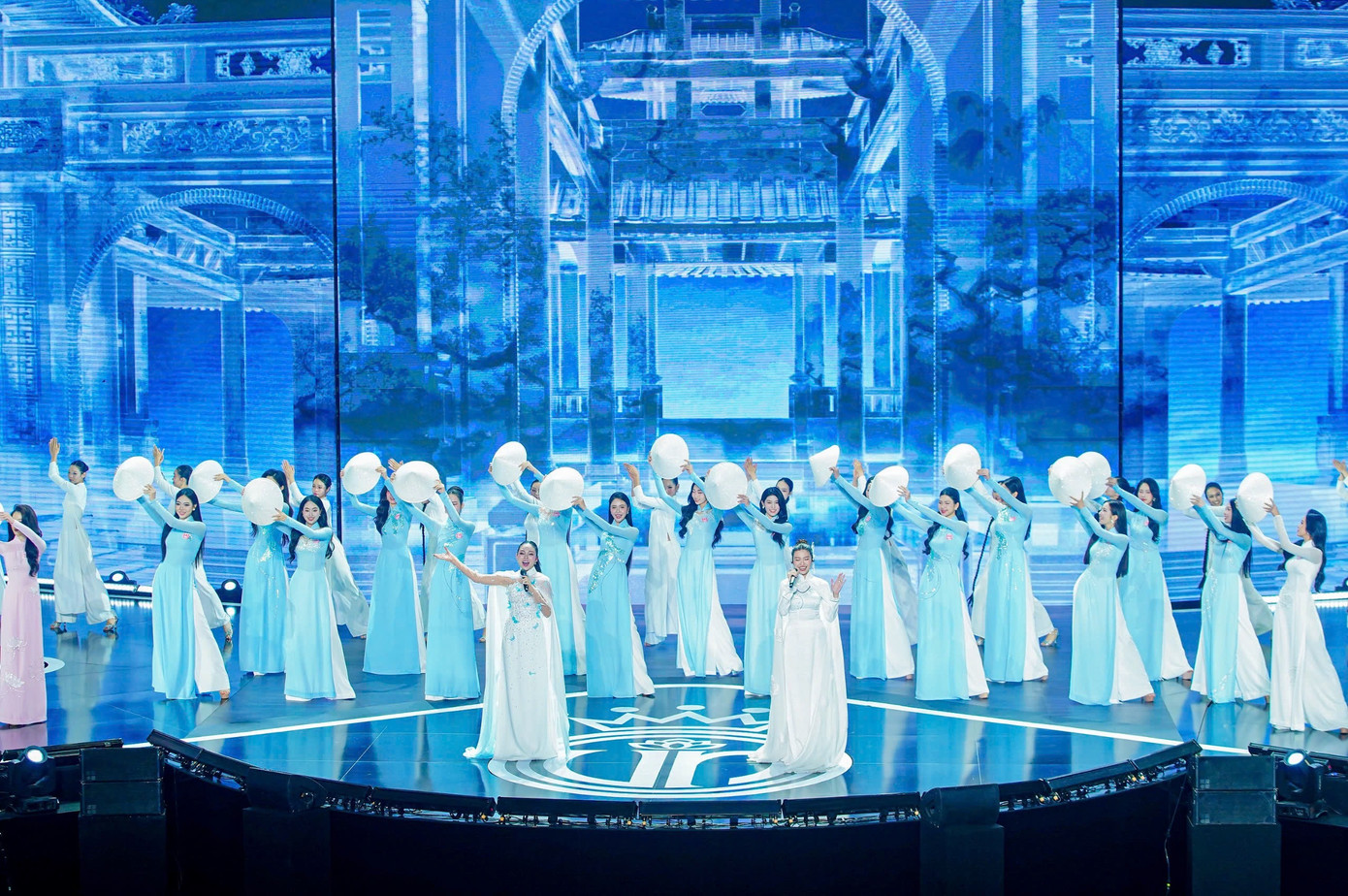 41 thí sinh đồng diễn áo dài trên nền nhạc Việt Nam hào quang rực sáng, được dàn dựng công phu kết hợp giữa âm nhạc, vũ đạo và tà áo dài truyền thống, chiếc nón lá. Phần thi thể hiện đậm nét tinh thần dân tộc và vẻ đẹp nữ tính của người phụ nữ Việt Nam. 41 thí sinh đồng diễn áo dài trên nền nhạc Việt Nam hào quang rực sáng, được dàn dựng công phu kết hợp giữa âm nhạc, vũ đạo và tà áo dài truyền thống, chiếc nón lá. Phần thi thể hiện đậm nét tinh thần dân tộc và vẻ đẹp nữ tính của người phụ nữ Việt Nam.