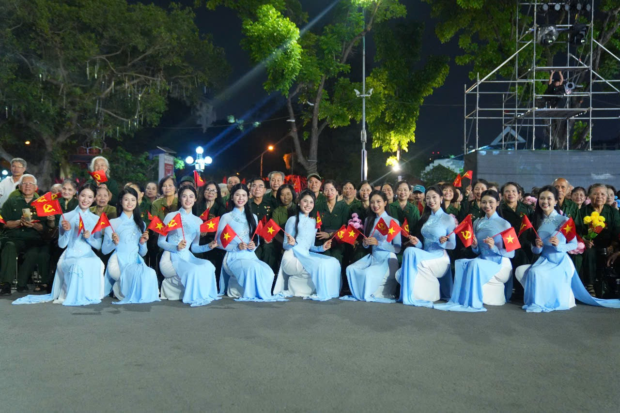 Khoảnh khắc thí sinh Hoa hậu Việt Nam chụp ảnh lưu niệm cùng các cựu chiến binh và thanh niên xung phong tại sự kiện.