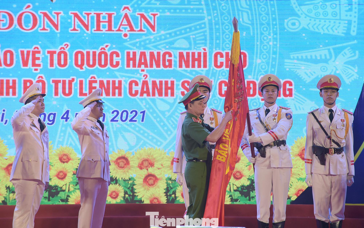 Trung tướng Phạm Quốc Cương - Tư lệnh Bộ Tư lệnh Cảnh sát Cơ động gắn Huân chương Bảo vệ Tổ quốc hạng Nhì lên lá cờ truyền thống của Đoàn Thanh niên Bộ Tư lệnh CSCĐ. Ảnh: Xuân Tùng
