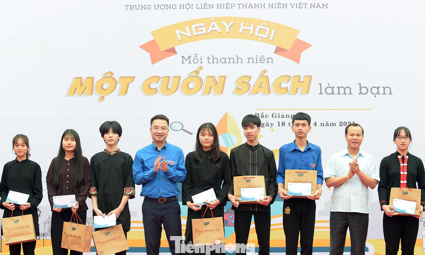 Anh Nguyễn Tường Lâm và ông Mai Sơn trao học bổng cho các học sinh. Ảnh: Xuân Tùng