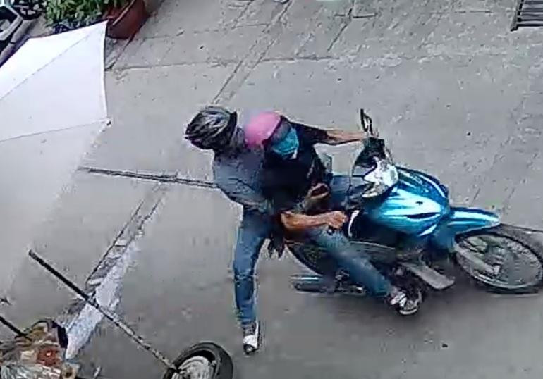 Hai thanh niên lên xe bỏ chạy sau khi cướp được điện thoại của chị H. (Ảnh cắt từ clip). Hai thanh niên lên xe bỏ chạy sau khi cướp được điện thoại của chị H. (Ảnh cắt từ clip).