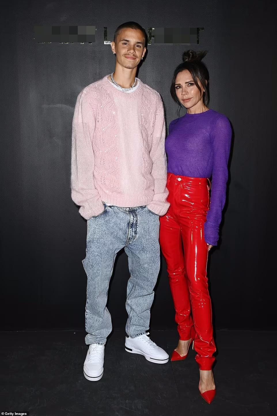 Tham dự show của thương hiệu xa xỉ Pháp còn có Victoria Beckham và con trai Romeo Beckham. Cựu thành viên Spice Girls thực sự tạo ấn tượng thị giác mạnh với trang phục màu sắc. Nhà thiết kế 48 tuổi phối áo len dài tay tím với quần da PVC và giày màu đỏ tươi.