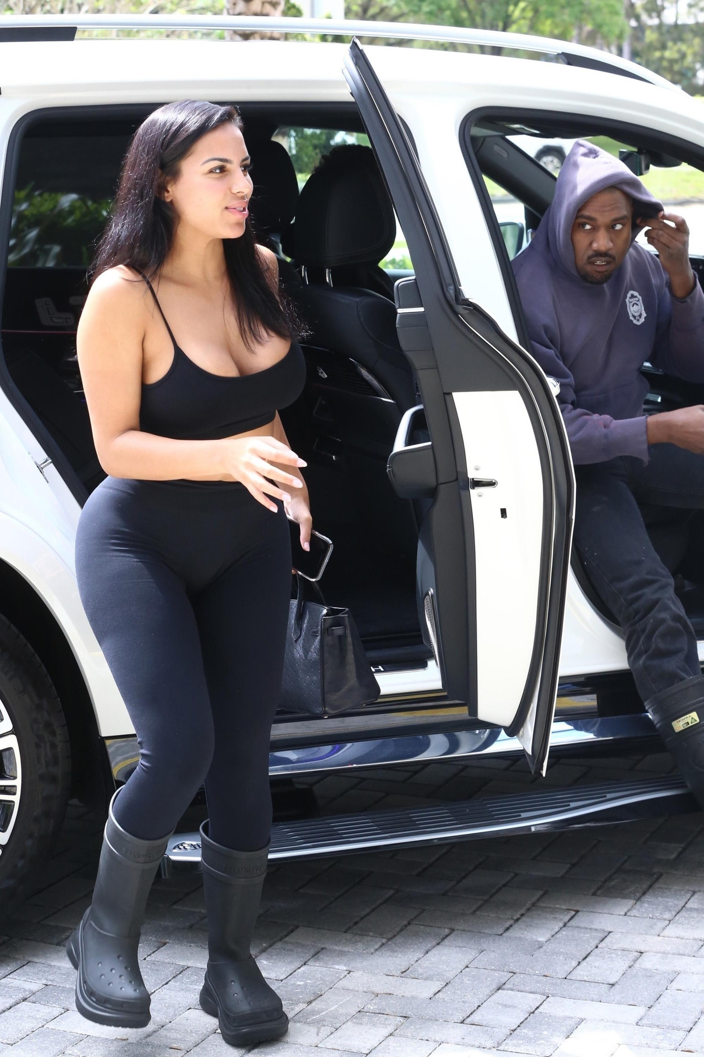 Hôm 1/3, cánh săn ảnh phát hiện Kanye West và Chaney Jones đi mua sắm cùng nhau ở Miami. Trong khi rapper 7x giữ gương mặt lạnh lùng, "bản sao Kim Kardashian" vui vẻ, rạng rỡ tương tác với ống kính máy ảnh.