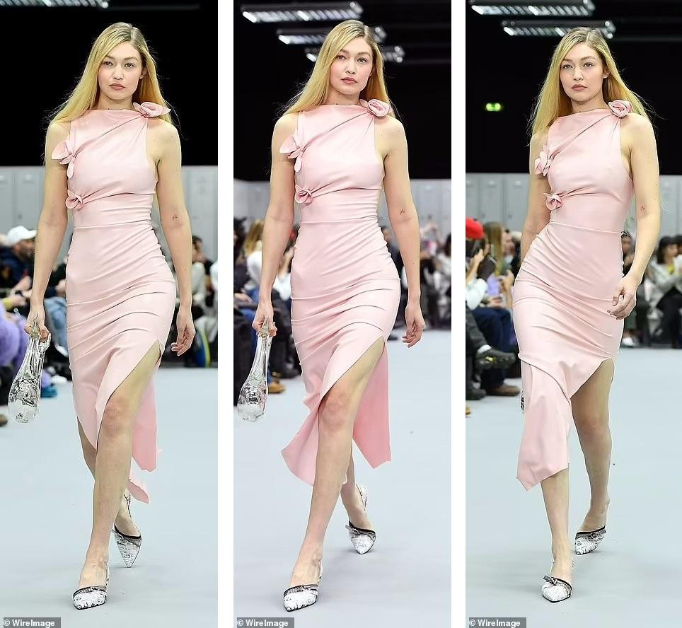 Cũng theo mốt "thả rông", Gigi Hadid sải bước thanh lịch và duyên dáng trong chiếc váy midi màu hồng baby với đường xẻ tà hai bên chân.