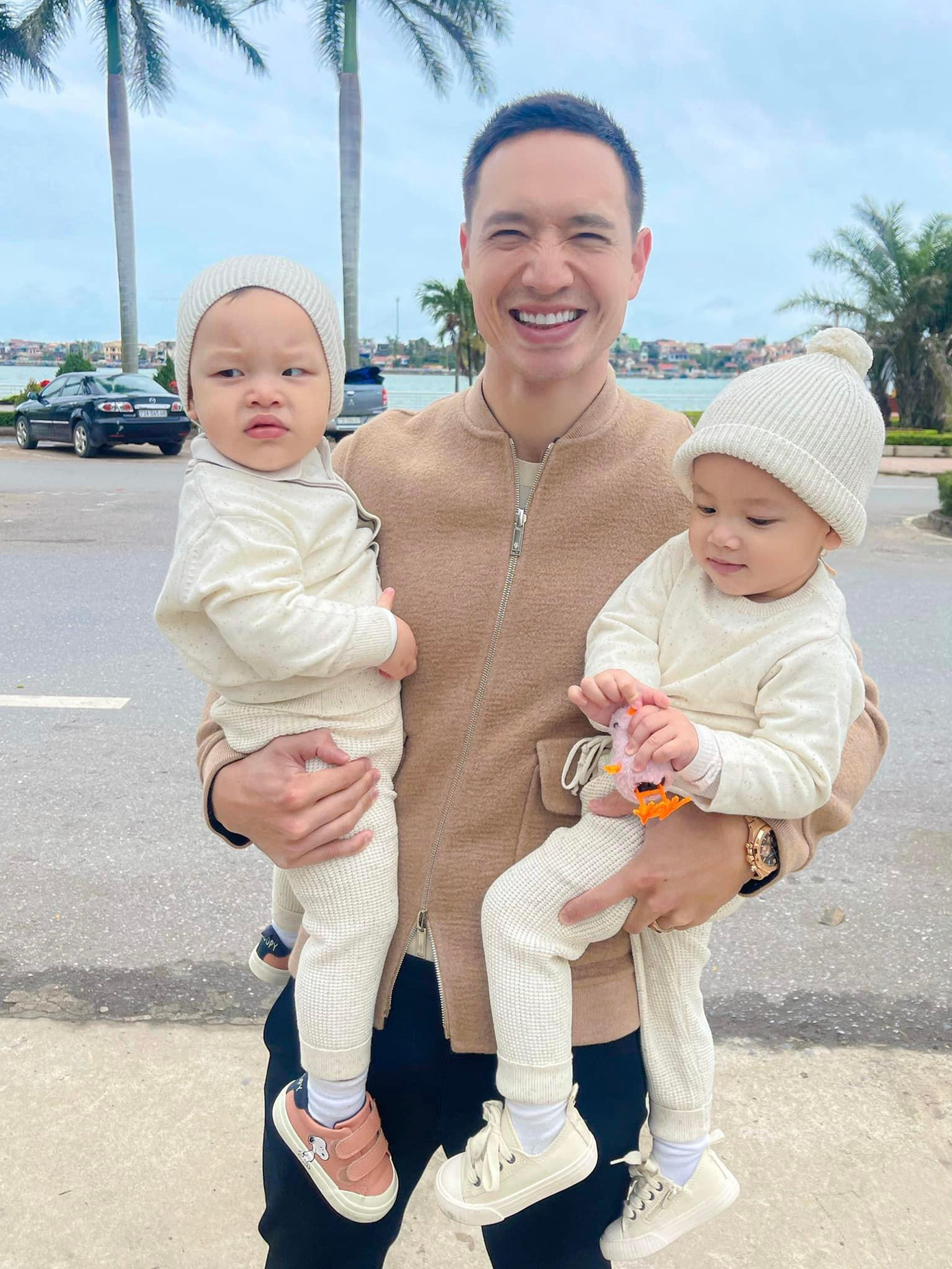 Kim Lý hai tay bế cặp song sinh Lisa và Leo trong chuyến về thăm Quảng Bình.