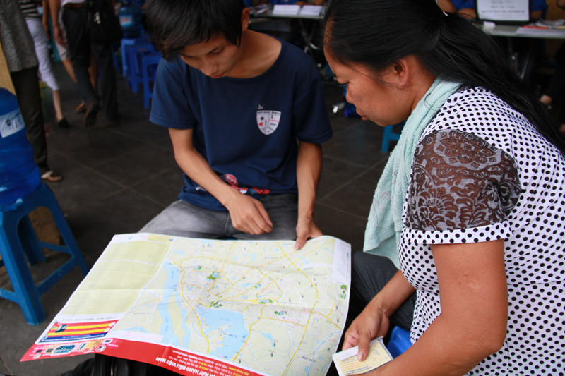 Hai mẹ con thí sinh tìm đường về nhà người quen. Ảnh: Trường Phong