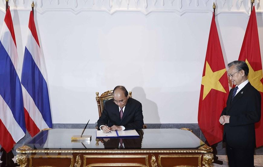 Chủ tịch nước Nguyễn Xuân Phúc viết lưu bút tại Quốc hội Thái Lan. (Ảnh: Thống Nhất/TTXVN)