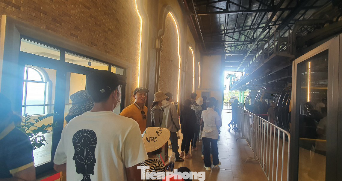 Bãi đỗ xe cho du khách và xe du lịch dưới chân núi chật ních, các khoang trong cabin cáp treo không còn chỗ trống.