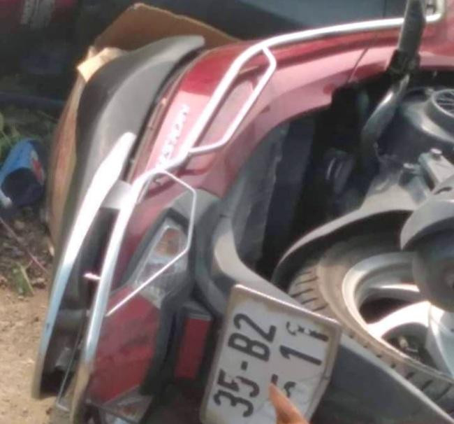 Chiếc xe máy văng xuống vệ đường sau khi va chạm với xe tải. Ảnh: NDC