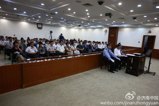 Ông Bạc Hy Lai mặc áo sơ mi trắng, quần đen được hai cảnh sát 