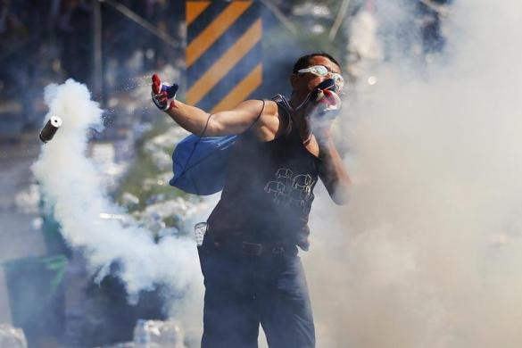 Người biểu tình ném lại lựu đạn cay vào cảnh sát