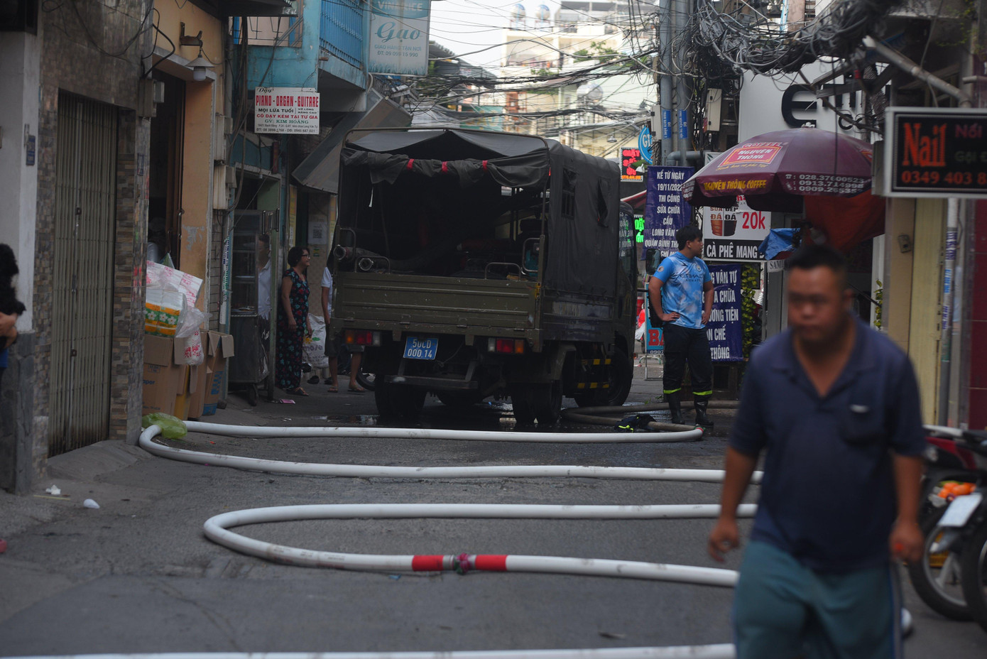 Lực lượng chức năng phải kéo đường ống nước chữa cháy vào trong hẻm.