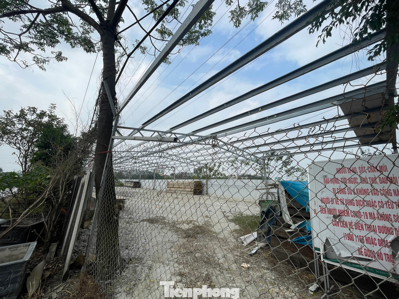 Phía ngoài hàng rào quây tôn của dự án, còn xuất hiện tình trạng người dân tự ý đổ đường bê tông, xây dựng nhà xưởng, đào ao, trồng cây ăn quả lâu năm. (Ảnh: Lập Đông)