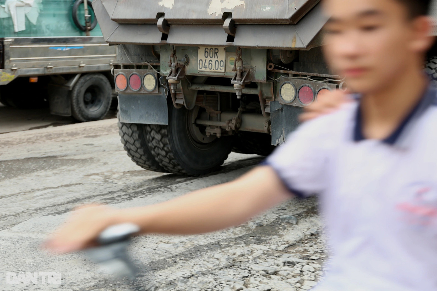 Bánh xe sau của một xe tải chênh vênh khi di chuyển qua tuyến đường chi chít ổ gà, ổ voi, rạch sâu.