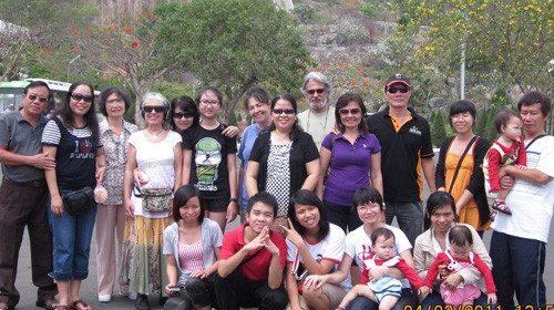 Minh (ngồi, thứ hai từ trái qua) trong một chuyến dẫn khách nước ngoài đi tham quan tại Vũng Tàu. Ảnh: nhân vật cung cấp