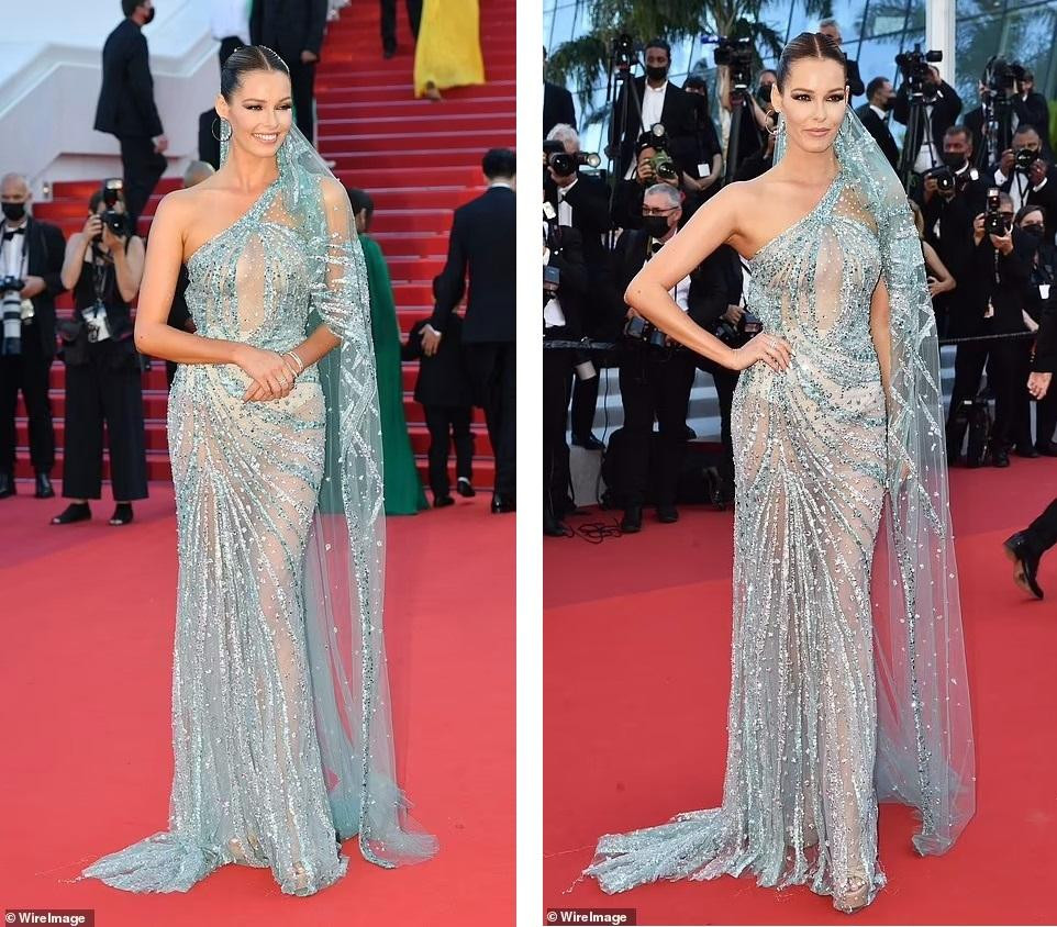 Hoa hậu Pháp 2018 Maeva Coucke là một trong những mỹ nhân tâm điểm của thảm đỏ Cannes ngày thứ 4 khi xuất hiện trong chiếc đầm lệch vai màu xanh lấp lánh. Thiết kế xuyên thấu giúp Coucke khoe đường cong hoàn mỹ, nóng bỏng, nhất là vòng một không nội y &quot;lấp ló&quot; sau lớp vải mỏng manh.