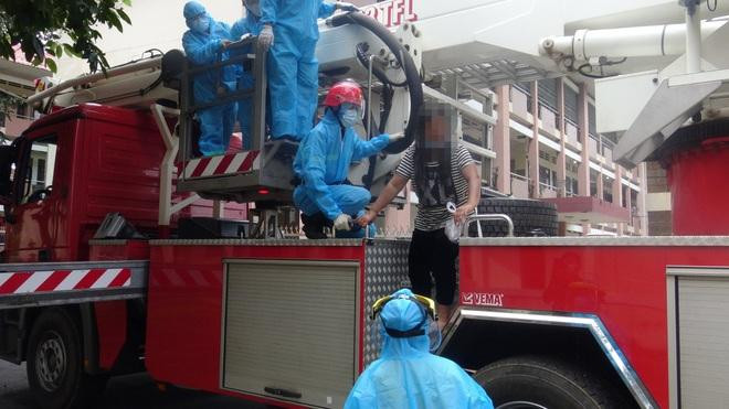 Lực lượng cứu hộ đưa người phụ nữ định tự tử xuống nơi an toàn. Ảnh: Dân trí