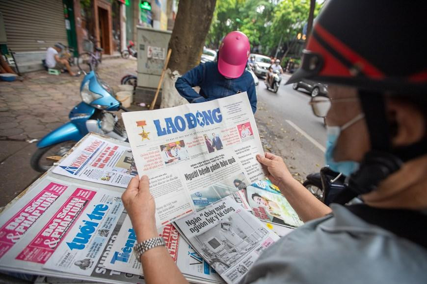 Khách hàng lui tới những sạp báo chủ yếu của chị là những người ngoài 50 tuổi và hầu hết là khách quen, lượng mua giảm nhiều nên mỗi ngày những sạp báo nhỏ như của chị Hòa chỉ dám nhập về 30 tờ một ngày. (Ảnh: Hoài Nam/Vietnam+)