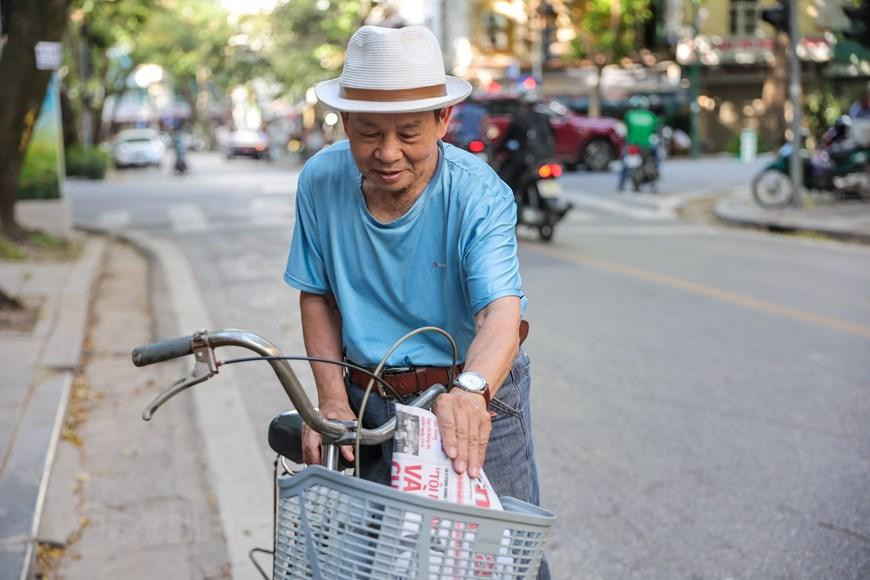 Ông Trần Minh Thư (85 tuổi) cho biết đến giờ vẫn lựa chọn báo giấy thay vì đọc báo điện tử do thói quen. Hàng ngày ông vẫn đạp xe đi mua báo rồi kiếm một quán cà phê để vừa thưởng thức vừa nghiền ngẫm tờ báo. (Ảnh: Minh Sơn/Vietnam+)