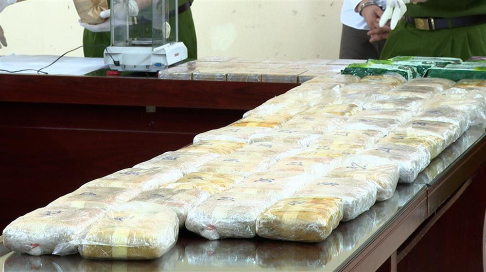 21 bánh heroin, tang vật vụ án. Ảnh: CA.