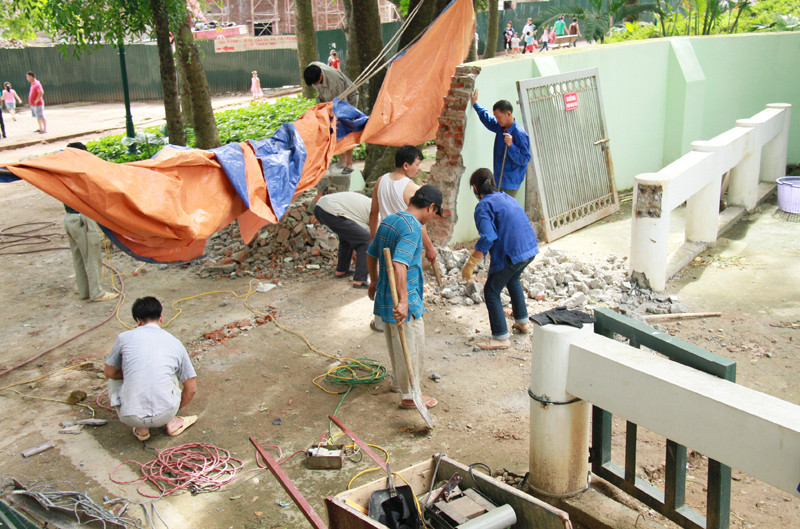 Một nhóm thợ đang sửa lại tường bao quanh chuồng voi. Nhiều du khách cho biết, nơi này được phá để xe vào chở xác voi Krông