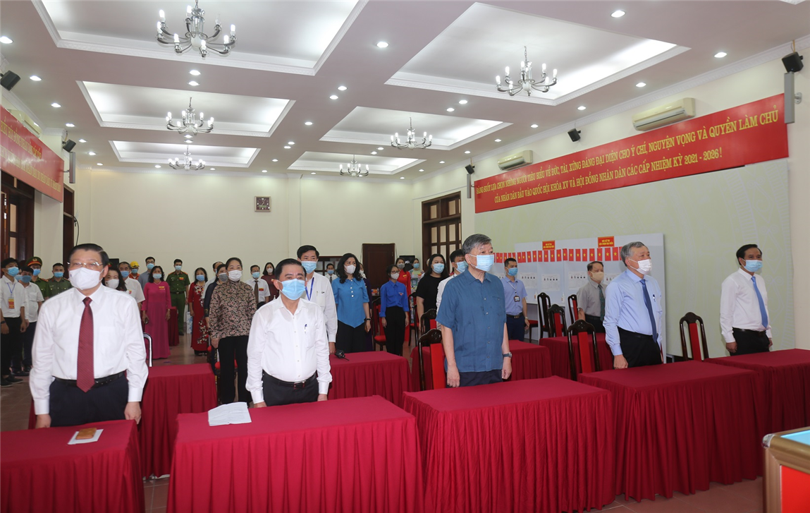 Bộ trưởng Tô Lâm với các đồng chí lãnh đạo và cử tri Điểm bỏ phiếu số 06 phường Quán Thánh thực hiện nghi lễ Chào cờ.