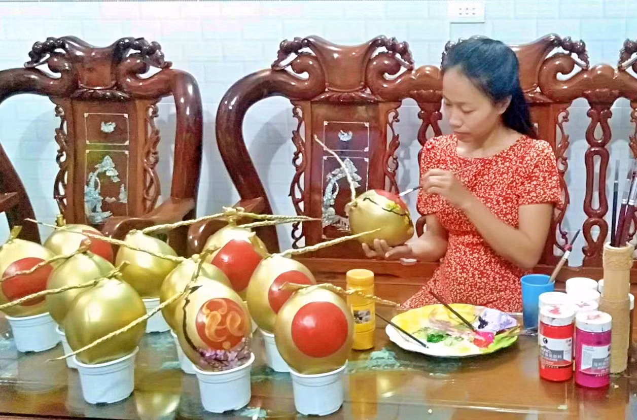 Trong khi đó, Thúy Thương chọn vẽ hình ảnh đặc trưng của Tết, thư pháp, câu chúc... lên trái dừa. (Ảnh nhân vật cung cấp).