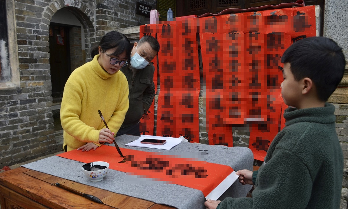 Một cô gái trẻ viết câu đối Tết hôm 16 tháng 1 năm 2023 tại Trung Quốc. Ảnh: VCG