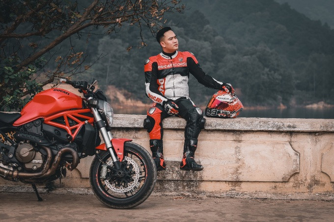 Anh Nguyễn Quốc Huy trong bộ đồ bảo hộ, bên cạnh chiếc xe phân khối lớn của mình (Ảnh: NVCC).