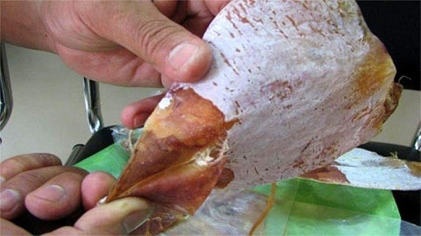 Mực khô gắn keo là cấp độ tiếp theo của “nghệ thuật” làm giả mực hiện nay. So với mực khô thông thường, loại mực này nhỏ hơn, hình thù gần giống lá trầu. Đuôi mực dễ dàng được bóc ra do dính bằng keo, râu không quăn và không hề có mắt như tự nhiên