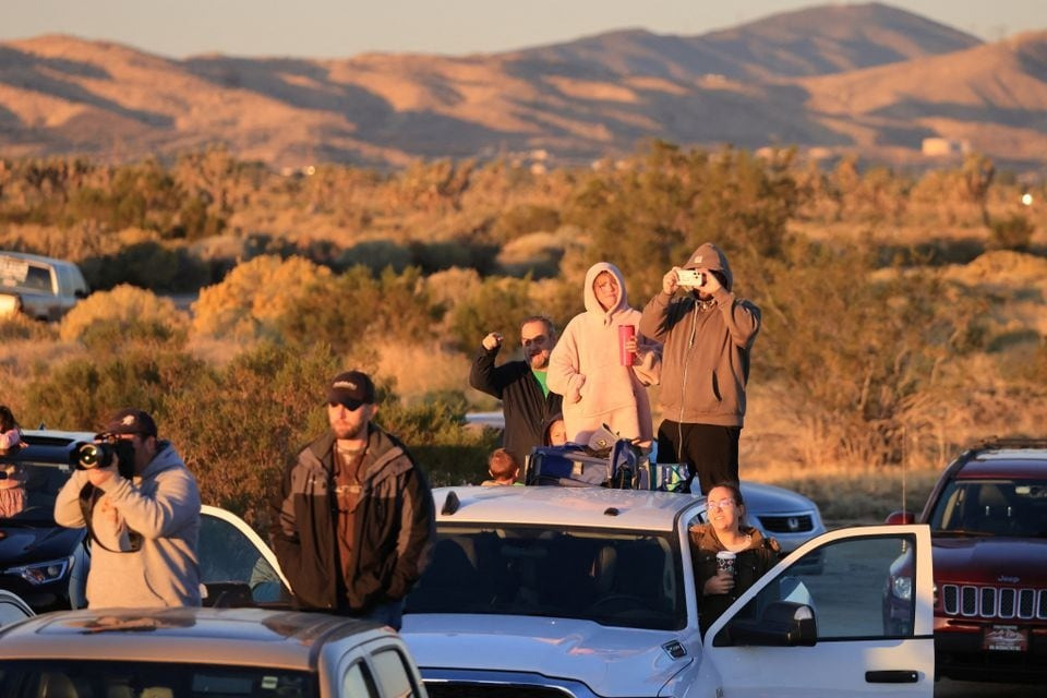 Các nhiếp ảnh gia hàng không và người dân đứng xem chuyến bay thử nghiệm. Ảnh: Reuters