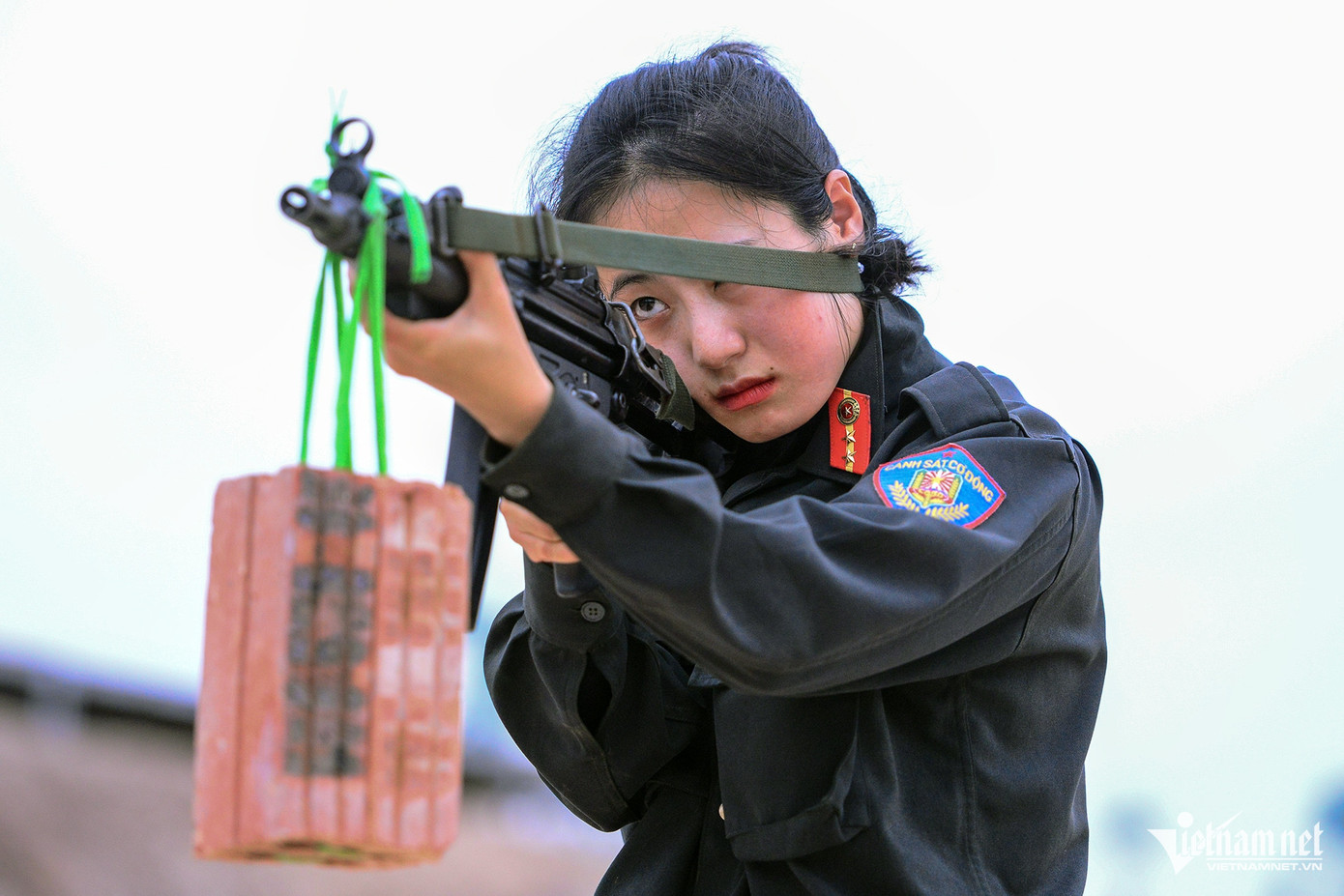 Trọng lượng của cả súng và gạch khoảng 5kg. Với một người bình thường sẽ là điều khó khăn nhưng với những nữ CSCĐ sau nhiều ngày rèn luyện, họ có thể khiến viên gạch không bị đung đưa khi ở trên không.