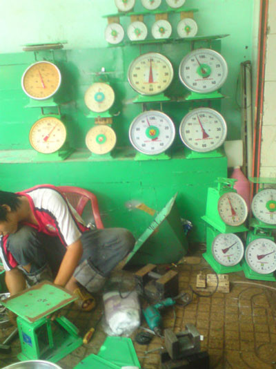 Nhân viên đang "phù phép" cho cân tại chợ Kim Biên. Nhân viên đang