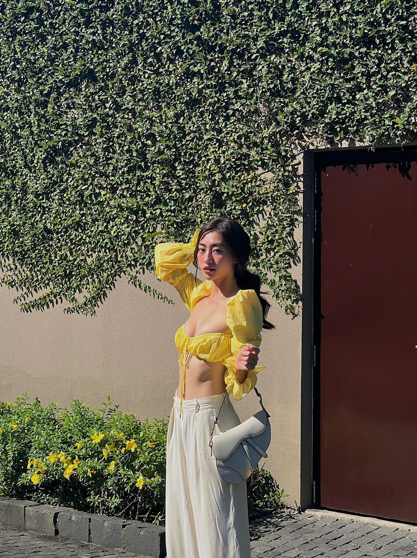 Hoa hậu Lương Thuỳ Linh mặc áo crop-top màu vàng khoe vòng eo 'con kiến' sexy.