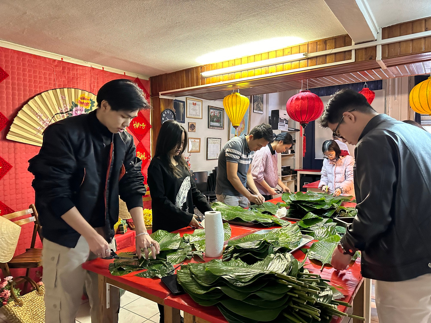 Các bạn trẻ cắt lá dong chuẩn bị gói bánh chưng