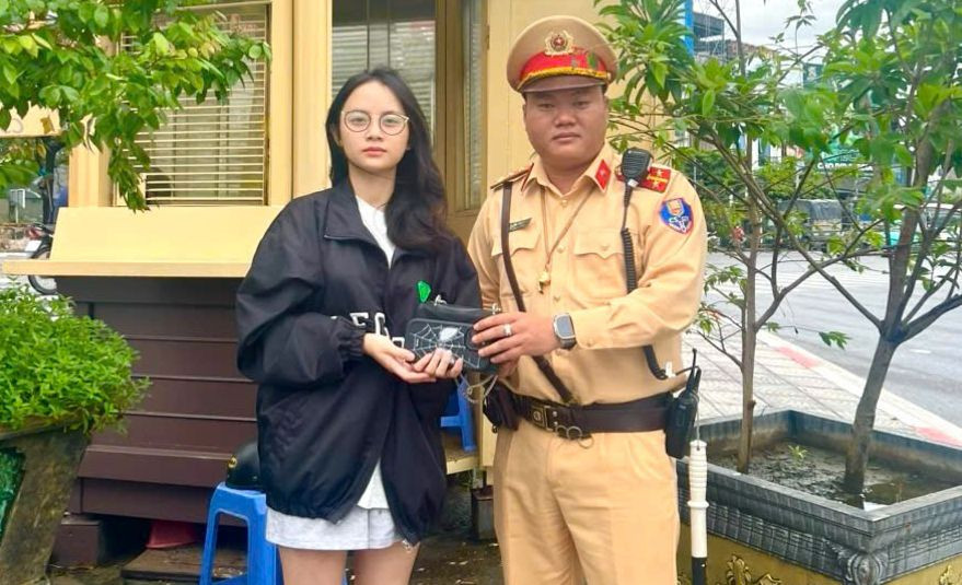Cán bộ CSGT trao trả lại tài sản cho chị Huyền.