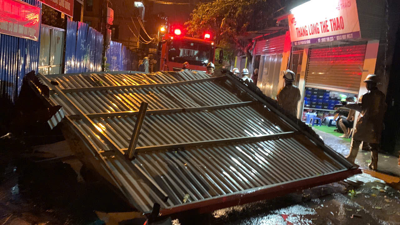 Trong ảnh, tổ công tác Đội Cảnh sát PCCC&amp;CNCH Công an quận Bắc Từ Liêm (Hà Nội) nhanh chóng có mặt di chuyển mái tôn lớn chắn ngang đường Phan Bá Vành.